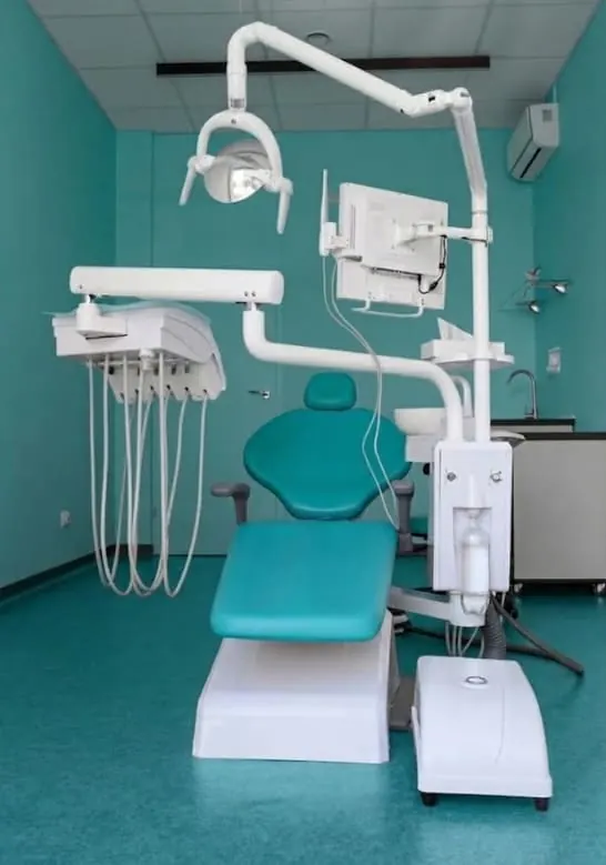A dental treatment room with a dental chair and unit